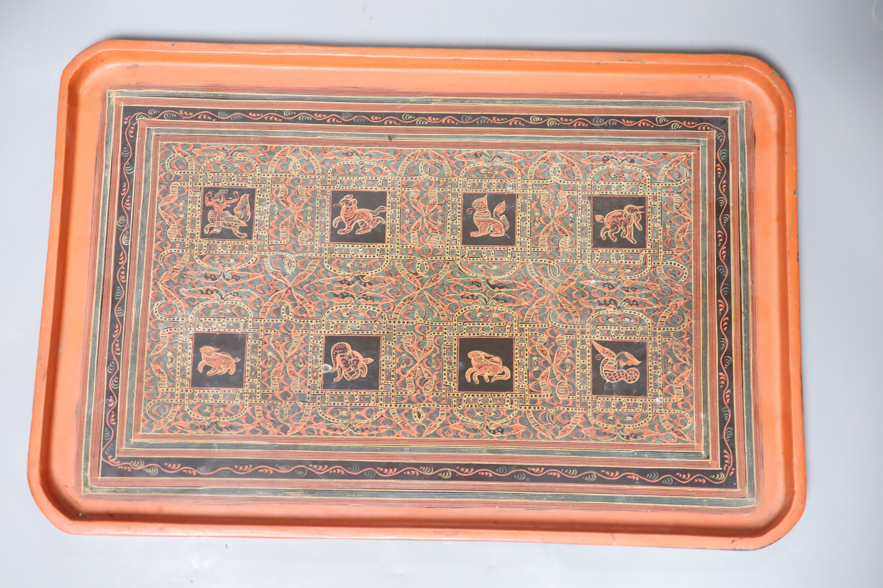 An African hardwood carving of a herd of elephants, and two papier mache trays, largest 46cm